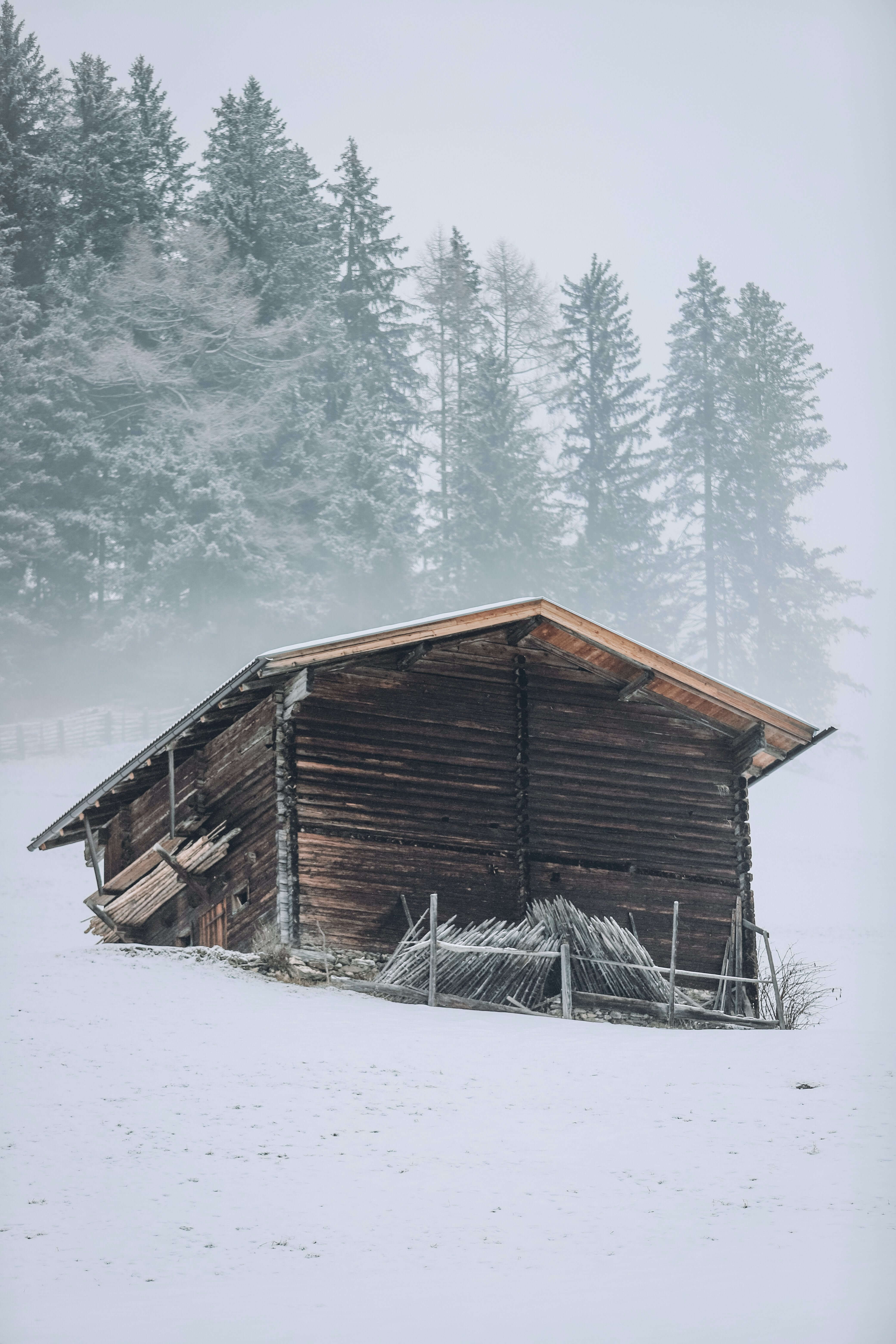photo of wood house on a snow mountain side